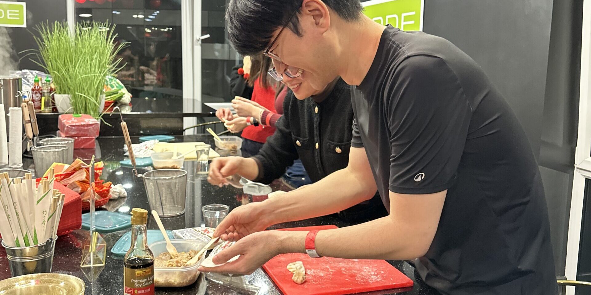 Woman teaching man how to make dumpling 