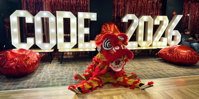 lion dancer with a lit up sign saying 'code 2026'